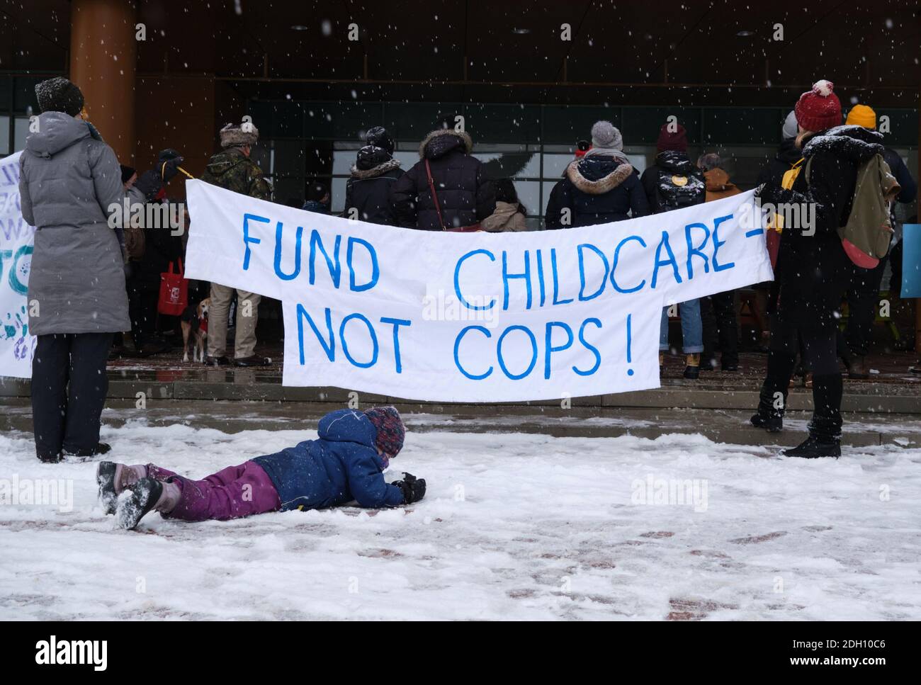 Ottawa, Canada. December 9th, 2020. Representative from various community groups protest against the 2021 city budget citing that in fails to address multiple crises. The group specifically argues against increase in police budget with banner ` Fund childcare not Cops. Credit: meanderingemu/Alamy Live News Stock Photo